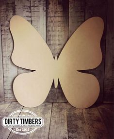 a paper cut out of a butterfly sitting on top of a wooden floor with the words dirty