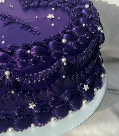 a purple cake with white pearls on it