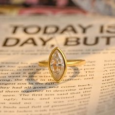 a gold ring sitting on top of an open book with the words today is day but