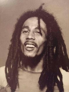 a black and white photo of a man with dreadlocks