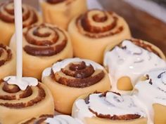 several cinnamon rolls with white icing on a plate