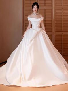 a woman in a white wedding dress posing for the camera with her hands on her hips