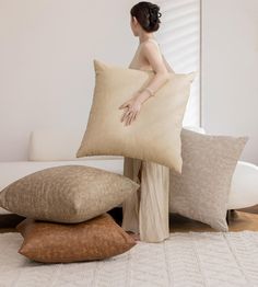 a woman sitting on a couch holding a pillow