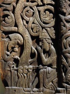 an intricate carving on the side of a wooden door with people and animals around it