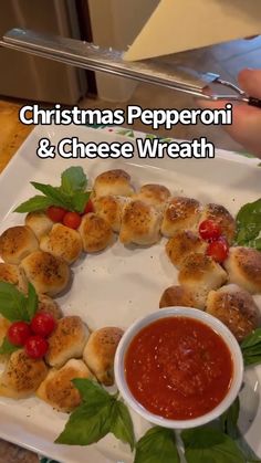 christmas pepperoni and cheese wreath on a white plate with tomato sauce in the middle