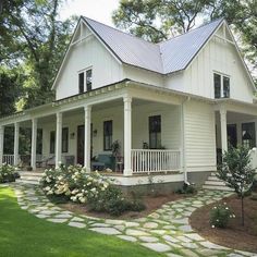 a white house with a blue roof and some flowers on the front lawn is featured in this post