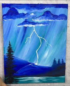 someone is painting a storm in the sky with blue and green colors on canvases