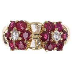 A fine quality ruby and diamond wide band in 18K yellow gold. Twelve, vivid, red rubies highlight the sides of the band and create an eye-catching design. Brilliant round and tapered baguette diamonds accent the well-designed ring. This is an elegant band with full finger coverage. Smooth and ideal for everyday wear. Setting Style: Cluster Setting Material: 18k Yellow Gold Main Stone: Ruby Shape: Round Estimated Weight: 1.44-Carats Clarity: Transparent Color: Red Luster: Excellent Treatment: Natural Secondary Stones: Diamond Shape: Brilliant Round/Tapered Baguettes Total Diamonds: 6 Weight: 0.44cts Clarity: VS Color: G-H Luster: Excellent Wide Gold Band, Van Cleef And Arpels, Baguette Diamonds, Colombian Emeralds, Ruby Diamond, Van Cleef, Baguette Diamond, Natural Ruby, Brilliant Diamond