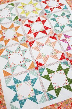 a quilted table topper with colorful stars on it