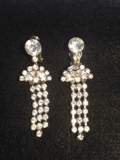 This pair is stunning-perfect for formal events !!   Earrings in good condition.  Unsigned. Quality made.  Prongs intact.  Very minimal wear seen in metal and on rhinestones when seaarching with a loupe only.  Clips function well and grip tightly.  Large round rhinestone at the top with square, 1  round, and marquis cut rhinestones below in a fan shape.  The 3 strands consist of square rhinestones. Please study photos closely.  Nice gift idea! Study Photos, Earrings Vintage, Antique Collection, The 3, Vintage Earrings, Evening Wear, Clip On, Formal Event, Etsy Vintage