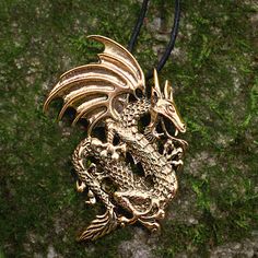 Once upon a time, there was a mighty dragon.... There's no doubt that this fierce beast belongs in a tale of heroes and epic adventures. A dragon is a fearsome enemy, but for one who chooses to befriend it, there is no more steadfast guardian. Is this pendant meant to be worn by men or women? Like most of our jewelry, this design is unisex. If you love it, you should wear it! The Bronze Dragon Pendant is quite large. There's nothing dainty or delicate about this dragon! If that appeals to your s Pagan Cross Stitch, Mighty Dragon, Celtic Cross Stitch, Dragon Cross Stitch, Bronze Dragon, Pendant Ideas, Carved Dragon, Leather Bound Journal, Dragon Jewelry