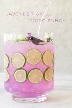 a pink drink with limes and lavender on the rim