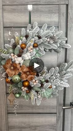 a wreath on the front door with ornaments and greenery hanging from it's sides