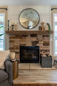 a living room with a fire place and mirror on the wall above it's mantle