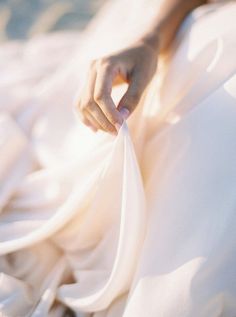 a woman in a white dress is holding something