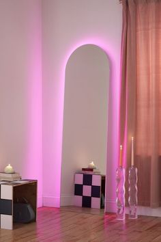 the room is decorated in pink and white with candles on the side table next to it