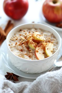 a bowl of oatmeal with apples and cinnamon on the side