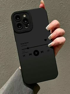 a woman's hand holding up a black phone case