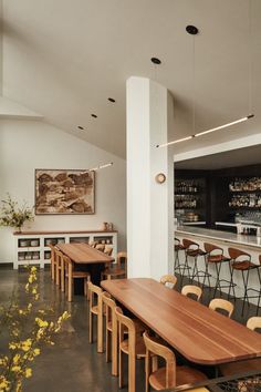 an empty restaurant with wooden tables and bar stools