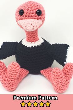 a crocheted stuffed bird sitting on top of a pink and white tablecloth