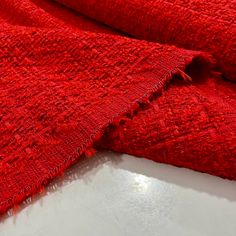 a red piece of cloth on top of a white table with the edge torn off