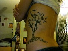 a woman with a tree tattoo on her stomach