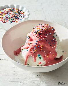 a bowl filled with ice cream and sprinkles on top of a table