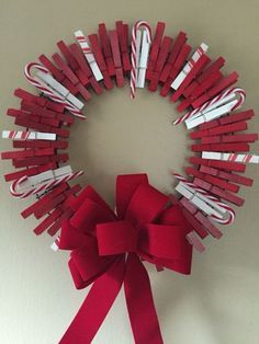 a christmas wreath made out of red and white candy canes with a bow on the front