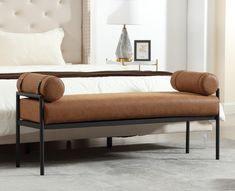 a brown bench sitting on top of a white bed