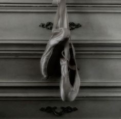 a ballerina's ballet shoes hanging on the wall