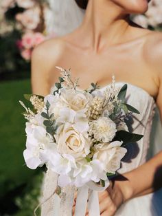 a bride holding a bouquet of white flowers