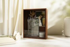 a wooden frame with the words christ and you on it next to a white flower