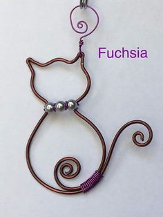 a metal cat with pearls on it's tail is hanging from a hook that says fuchsia