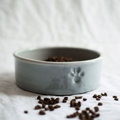 a dog bowl filled with food on top of a white table covered in brown flakes