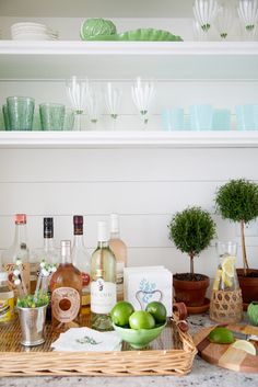 the kitchen counter is covered with bottles, glasses, and other items that are on display