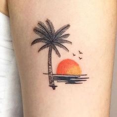 a small palm tree and sunset tattoo on the arm