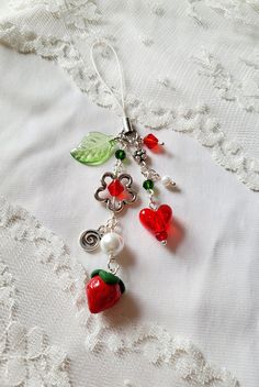 a close up of a piece of jewelry on a white cloth with beads and charms