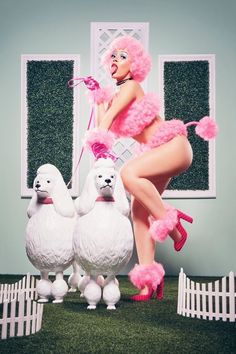 a woman in pink is standing next to three poodles