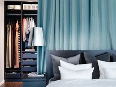 a bedroom with blue curtains and white pillows