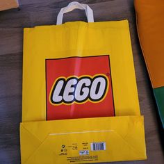 a yellow lego bag sitting on top of a wooden floor