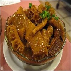 a bowl filled with meat and vegetables on top of a table