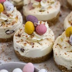 small desserts are arranged on a tray with candy eggs and marshmallows