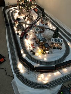 a toy train set is shown with christmas lights