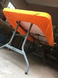 an orange tent sitting on top of a metal stand