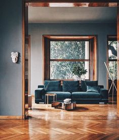 a living room with wood floors and blue couches in it's center area