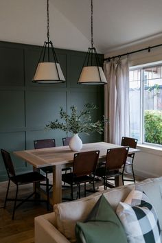 an instagram photo of a dining room with green walls and white curtains on the windowsill