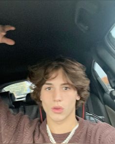 a young man sitting in the back seat of a car