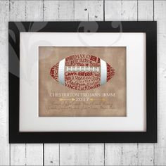 a framed football print with the name and team names on it, hanging on a wooden wall