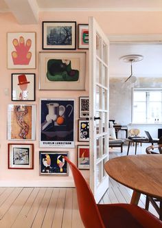 an open door leading to a dining room with pictures on the wall and wooden floors