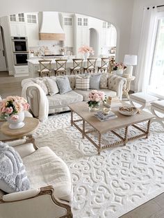 a living room filled with lots of furniture and flowers on top of a coffee table